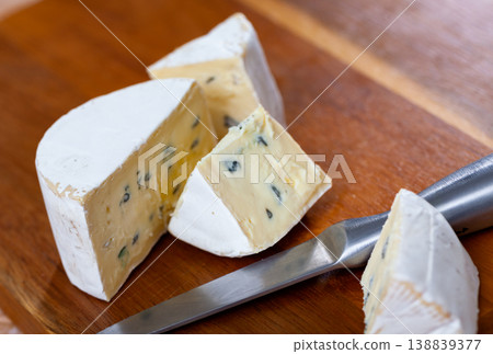 Pieces of soft blue cheese and knife on wooden cutting board Pieces of soft blue cheese and knife on wooden cutting board 138839377