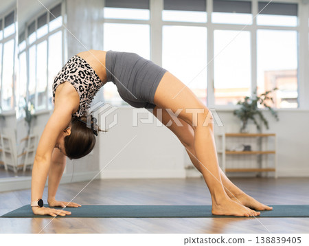 Young woman practicing vinyasa yoga in studio 138839405