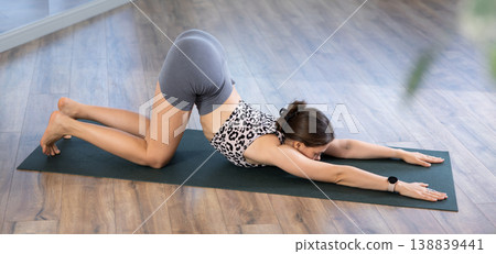 Sporty young woman performing advanced yoga posture in studio 138839441