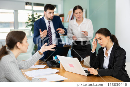 Group of colleagues scolding sad woman in office Group of colleagues scolding sad woman in office 138839446