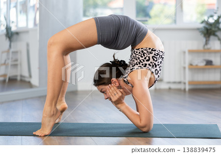 Sporty young girl performing dynamic asanas in yoga studio 138839475