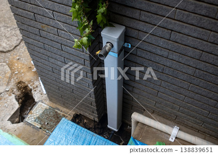 New outdoor piping and equipment installation site on the exterior wall of a house New outdoor piping and equipment installation site on the exterior wall of a house 138839651