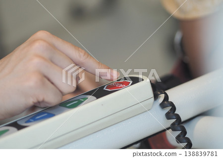 Hand pressing stop button on control panel in a workshop Hand pressing stop button on control panel in a workshop 138839781
