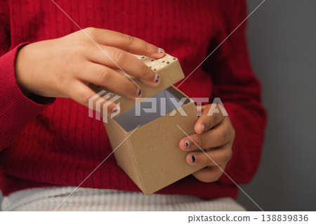 Child opens a small box with a brown lid Child opens a small box with a brown lid 138839836