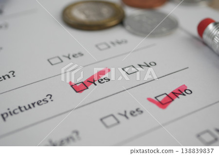 Checkmarks on a survey form with coins and a pen Checkmarks on a survey form with coins and a pen 138839837