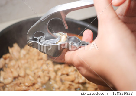 Cooking with a garlic press in a home kitchen setting 138839838