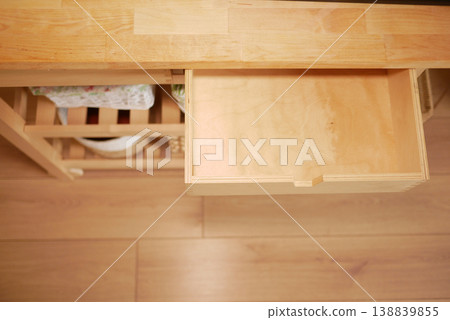 Wooden drawer in a kitchen cabinet is partially open 138839855