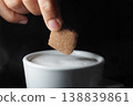 Dipping a biscuit piece into warm coffee 138839861