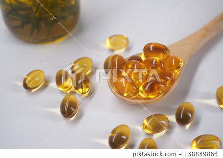 Oil capsules are placed on a wooden spoon in a simple setup 138839863