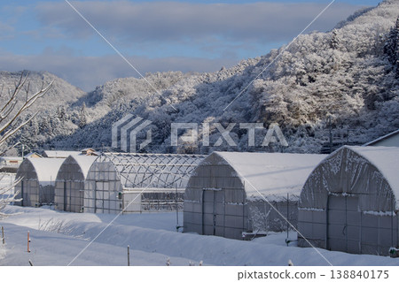A snowy morning in winter; a mountain village scene in winter; fresh snow piled on the trees and a house. A snowy morning in winter; a mountain village scene in winter; fresh snow piled on the trees and a house. 138840175