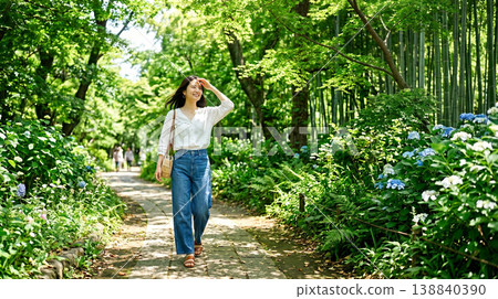 A refreshing woman walking through a park surrounded by fresh greenery. A refreshing woman walking through a park surrounded by fresh greenery. 138840390