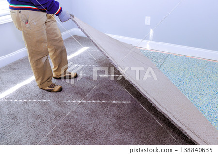 Handyman removes carpet from floor during home renovation project Handyman removes carpet from floor during home renovation project 138840635