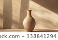 一張極簡風格陶瓷花瓶的照片，背景是溫暖的米色。 138841294