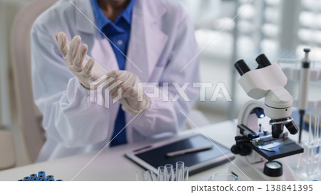 Scientist researcher prepares experiment laboratory adult person wears protective gloves medical safety scientific study work cleanroom environment 138841395