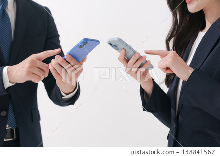 Two business people looking at their smartphones 138841567