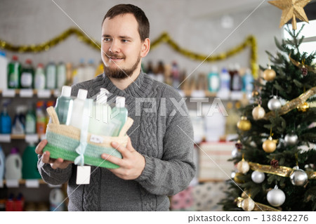 Interested nice bearded man choosing gifts for New Year in household department of supermarket 138842276