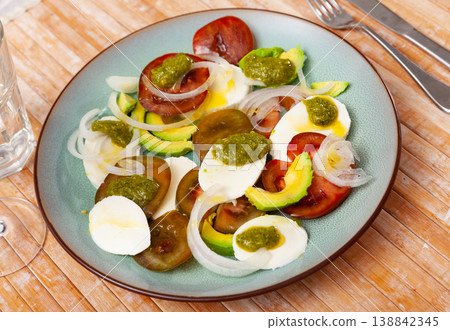 Salad with tomatoes, mozzarella, onion, avocado with pesto 138842345