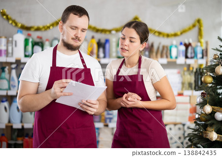 Retail workers discussing inventory results in personal care products store 138842435