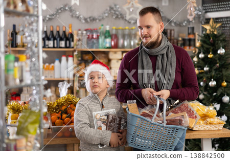 Young man with son choosing products in grocery store 138842500
