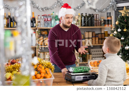 Man seller weighs candies for boy buyer 138842512