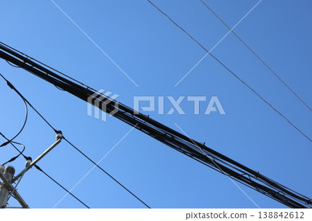 The sound of the after-school bell ringing against a blue sky and telephone poles: an expression that evokes memories of youth. The sound of the after-school bell ringing against a blue sky and telephone poles: an expression that evokes memories of youth. 138842612