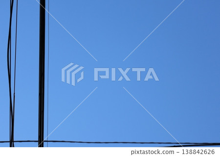 Utility poles and power lines towering against a clear blue sky: A clean, cloudless landscape. 2 138842626