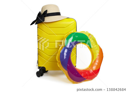 Yellow suitcase with straw hat and colorful inflatable ring on white background. Yellow suitcase with straw hat and colorful inflatable ring on white background. 138842684