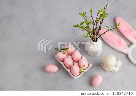 Easter holiday with pastel pink eggs, vase with branches and bunny ears on grey background Easter holiday with pastel pink eggs, vase with branches and bunny ears on grey background 138842710