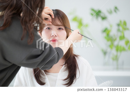 畫面中,一位女模特兒和一位髮型師正在為拍攝做準備,或是在美髮沙龍進行髮型設計。 畫面中,一位女模特兒和一位髮型師正在為拍攝做準備,或是在美髮沙龍進行髮型設計。 138843317