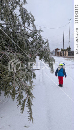 Child moves along snowcovered path wearing bright clothing Child moves along snowcovered path wearing bright clothing 138843372