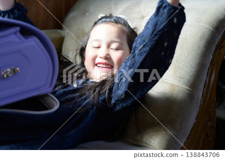 A Japanese girl with a schoolbag wakes up from a nap on the sofa. A Japanese girl with a schoolbag wakes up from a nap on the sofa. 138843706