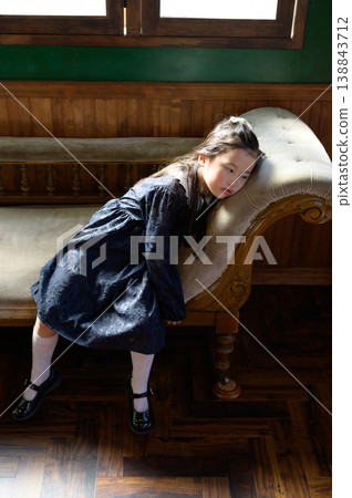 A Japanese girl leaning back on a sofa A Japanese girl leaning back on a sofa 138843712