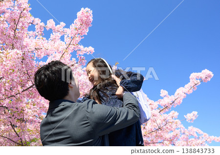 A Japanese father lifts his child under a cherry tree. A Japanese father lifts his child under a cherry tree. 138843733