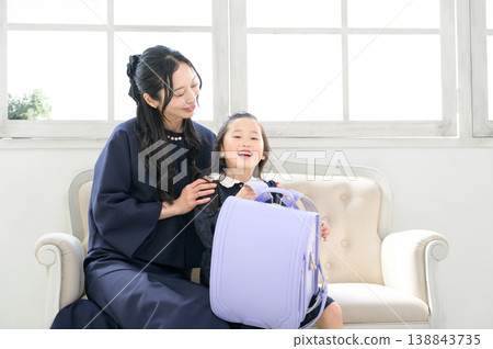 A Japanese parent and child talking with school bags beside them. 138843735