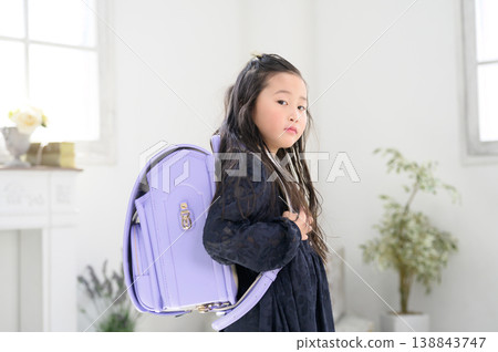 A Japanese girl turns around with her schoolbag on her back. A Japanese girl turns around with her schoolbag on her back. 138843747