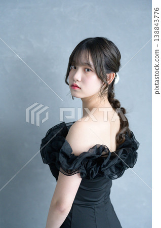 一位身穿黑色連身裙的日本女性,背景為灰色。 一位身穿黑色連身裙的日本女性,背景為灰色。 138843776