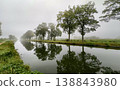 Misty River Reflections Surrounded by Lush, Green Trees in a Beautiful Natural Setting 138843980