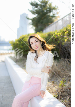 A young woman relaxing beside the bushes in the park. A young woman relaxing beside the bushes in the park. 138844104