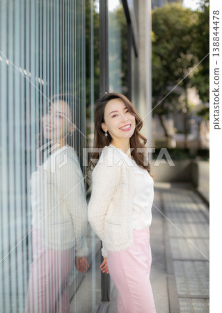 A young woman standing in the daytime city skyline. A young woman standing in the daytime city skyline. 138844478