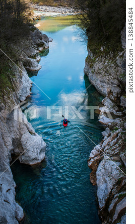 Kayaker paddling in Soca River turquoise canyon in Julian Alps Slovenia. Vertical shot Kayaker paddling in Soca River turquoise canyon in Julian Alps Slovenia. Vertical shot 138845484