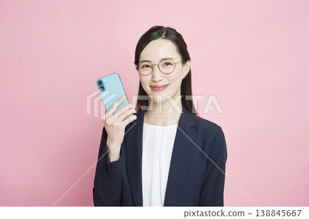 Businesswoman with a smartphone, pink background Businesswoman with a smartphone, pink background 138845667