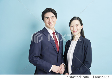 Businessmen and businesswomen standing side by side, smiling. Businessmen and businesswomen standing side by side, smiling. 138845683