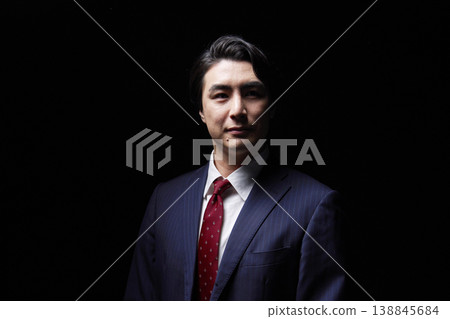 Portrait of a businessman in his 30s in darkness Portrait of a businessman in his 30s in darkness 138845684