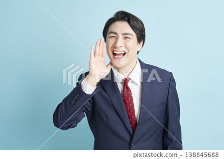 A businessman cheering with his hand over his mouth. A businessman cheering with his hand over his mouth. 138845688