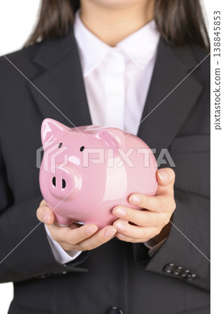 一位穿著西裝的女士拿著存錢罐 138845853