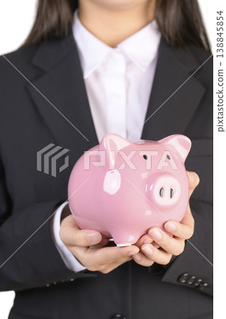 一位穿著西裝的女士拿著存錢罐 138845854