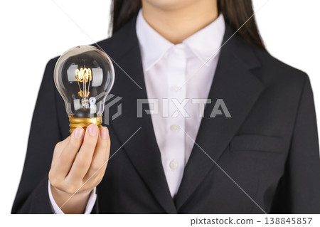 一位身穿西裝的女士拿著一個燈泡 138845857