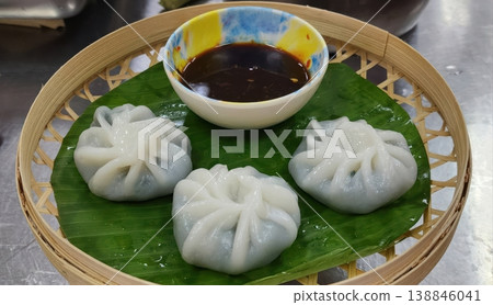Freshly Steamed Chinese Dim Sum Dumplings Served on Banana Leaf in Bamboo Basket Freshly Steamed Chinese Dim Sum Dumplings Served on Banana Leaf in Bamboo Basket 138846041