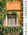 Sunlit Brick Window With Flower Box, Ivy And Yellow Roses On A Charming Balcony 138846258