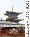 Traditional Pagoda Temple With Golden Roof and Pink Blossom Trees in Serene Spring Setting 138846261
